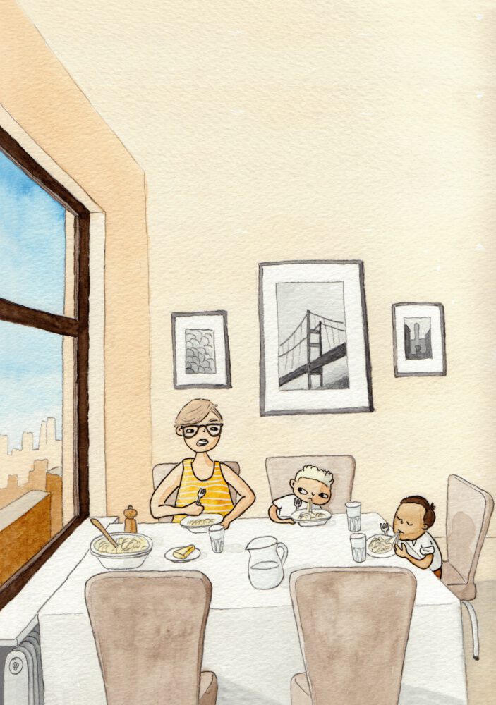 En mamma och två barn sitter vid köksbordet och äter.