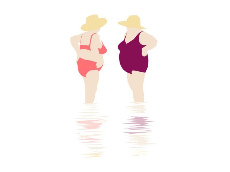 Två damer står i badräkt och hatt vatten på strand