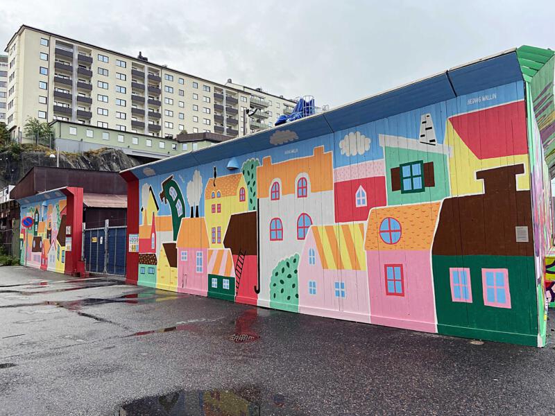 Färgglad muralmålning vid Stenpiren i centrala Göteborg. Den stora väggmålningen föreställer färgglada och fantasifulla hus.