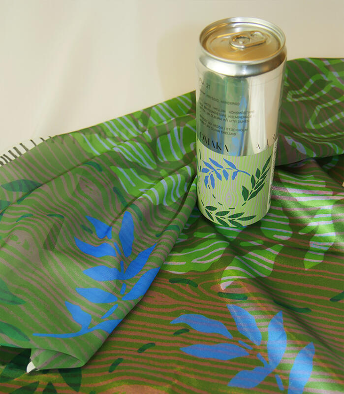 ölburk från OMAKA x AIRA tillsammans med ett tryckt tyg med löv, trä och botanik, naturmotiv 