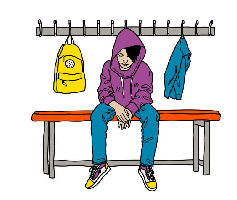 Pojke i hoodie som sitter på en bänk i skolan och mår dåligt, ser ledsen ut.