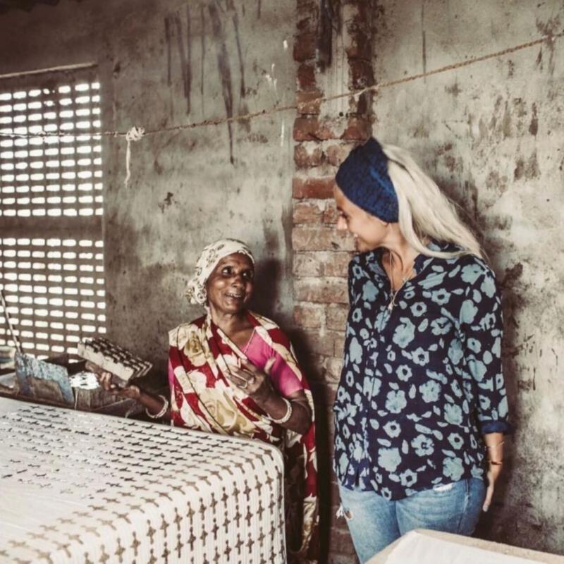 Två kvinnor som samtalar över en bit tyg i Indien
