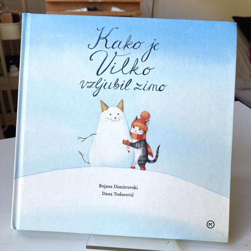 Illustration av en katt som leker i snön, gör en kattsnögubbe