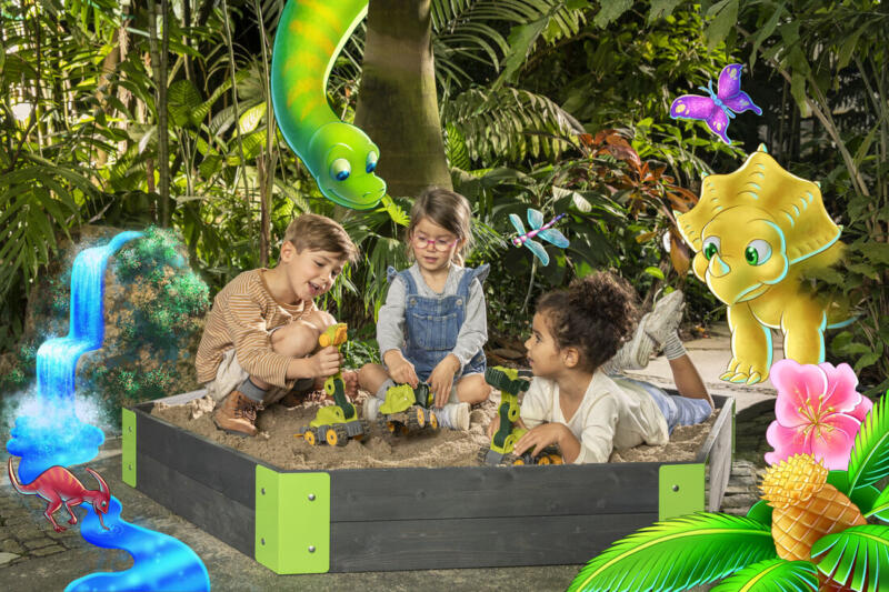 Tecknade dinosaurier samlas kring fotograferade barn som leker med leksaker i en sandlåda.