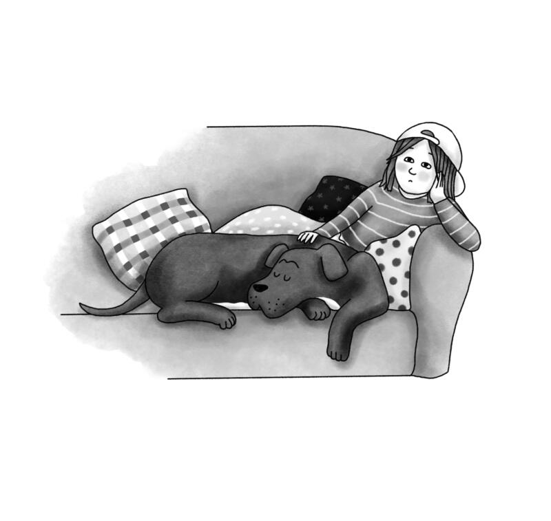 Flickan Vicky ligger i soffan tillsammans med sin stora hund.
