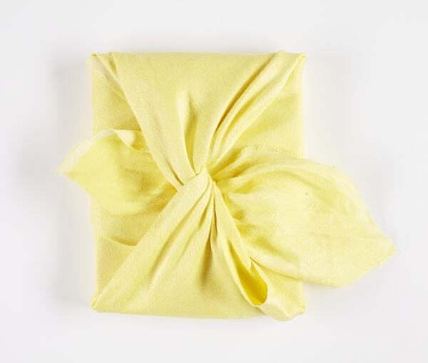 Bokomslag med handvävd knuten gul japansk furoshiki textil gjord av författaren. Furoshiki är en japansk textil och förpackningskonst. 