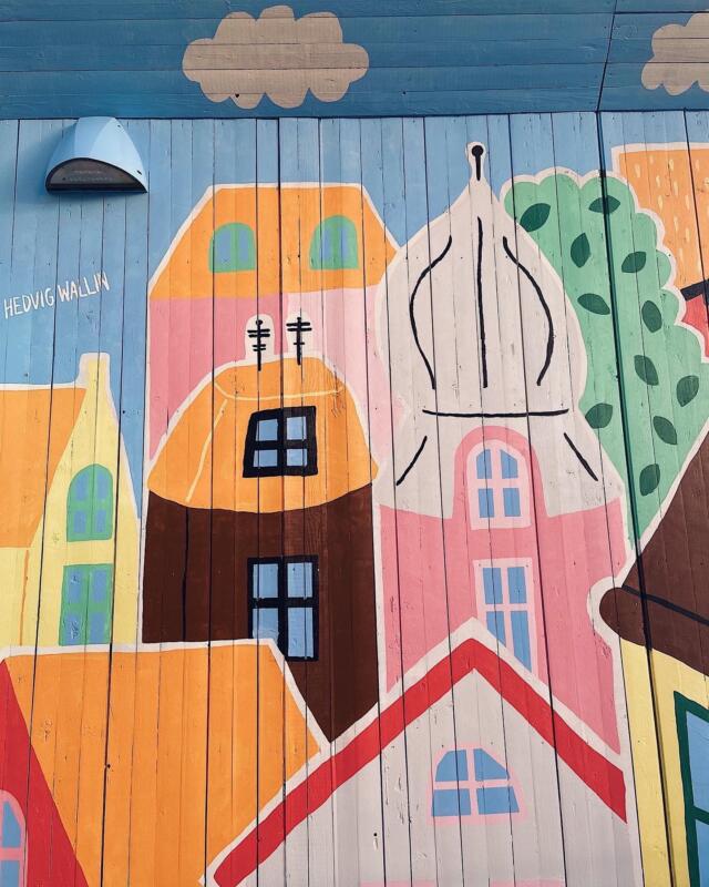 Färgglad muralmålning vid Stenpiren i centrala Göteborg. Den stora väggmålningen föreställer färgglada och fantasifulla hus.