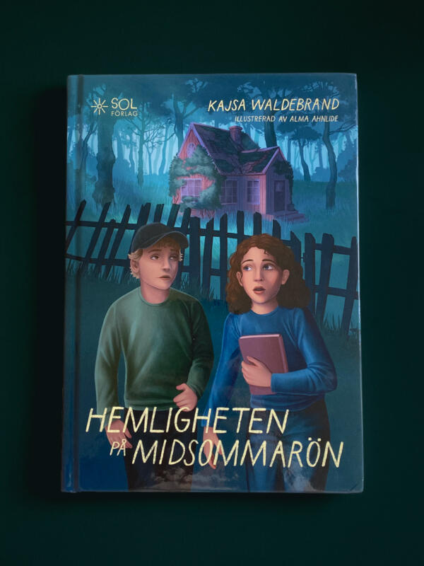 Omslag till boken Hemligheten på Midsommarön. Omslaget föreställer en pojke och en flicka som står framför ett förfallet hus i skogen på natten. Flickan håller i en dagbok.