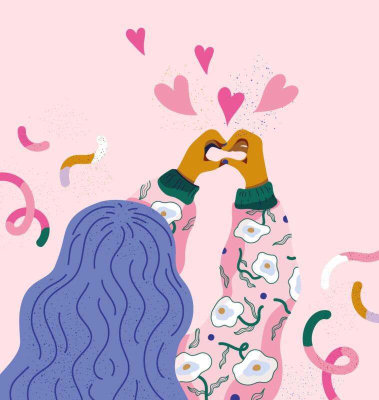 Flicka/tjej/kvinna som sträcker upp händerna och gör en hjärtan-symbol med händerna. Hon har blått hår, blommig jacka och är omgiven av girlanger.