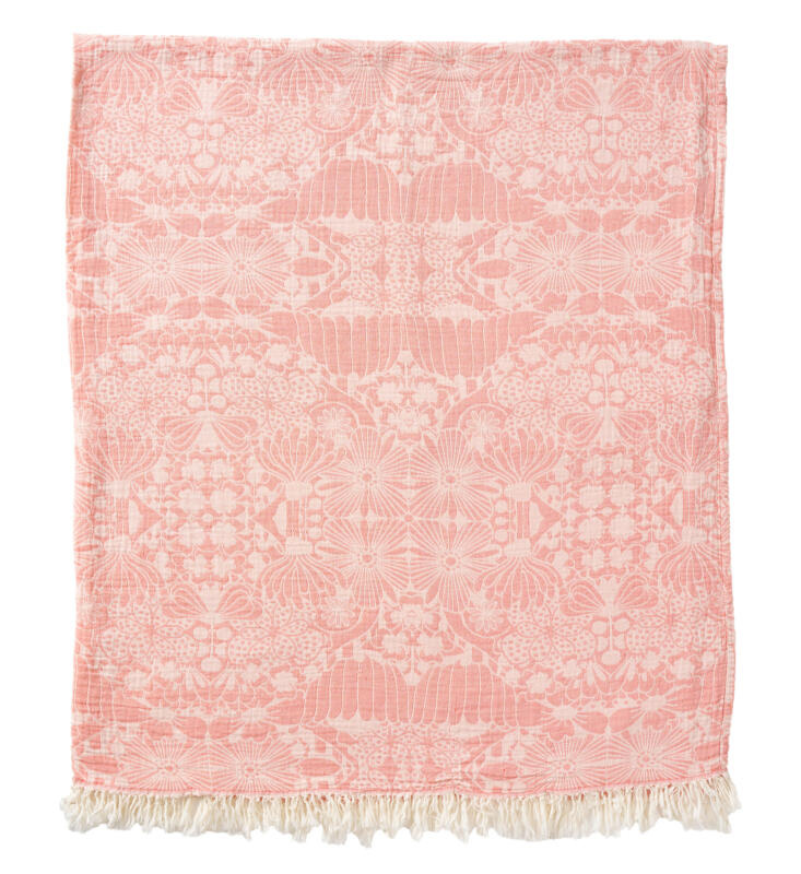 Vikt bomullsfilt med fransar med ett blommigt speglat och rapporterat mönster i ljusrosa och vitt.