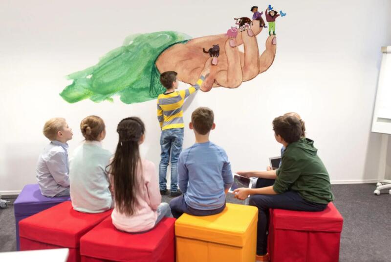 Färgglad väggmålning föreställande en hand som leker. Den lekfull i sitt uttryck och präglas av mjuka former, starka färger och ett organiskt bildspråk. passar i offentliga miljöer, skolor, förskolor eller kreativa rum.