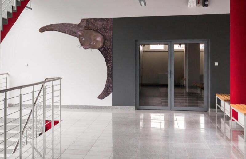 Färgglad väggmålning föreställande en katt. Den lekfull i sitt uttryck och präglas av mjuka former, starka färger och ett organiskt bildspråk. passar i offentliga miljöer, skolor, förskolor eller kreativa rum.