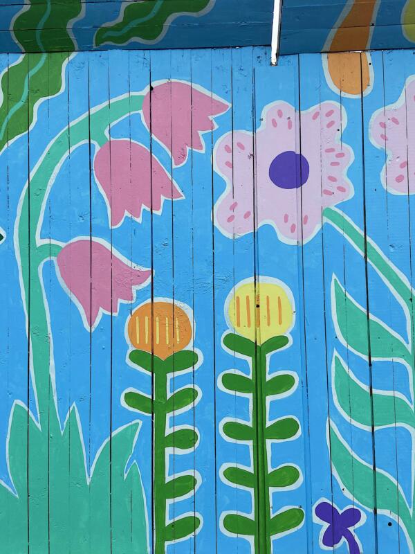 Detaljer av en väggmålning / muralmålning på ett byggplank i Göteborg. Målningen består av färgglada, fantasifulla blommor.