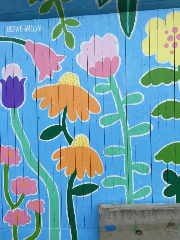 Detaljer av en väggmålning / muralmålning på ett byggplank i Göteborg. Målningen består av färgglada, fantasifulla blommor.