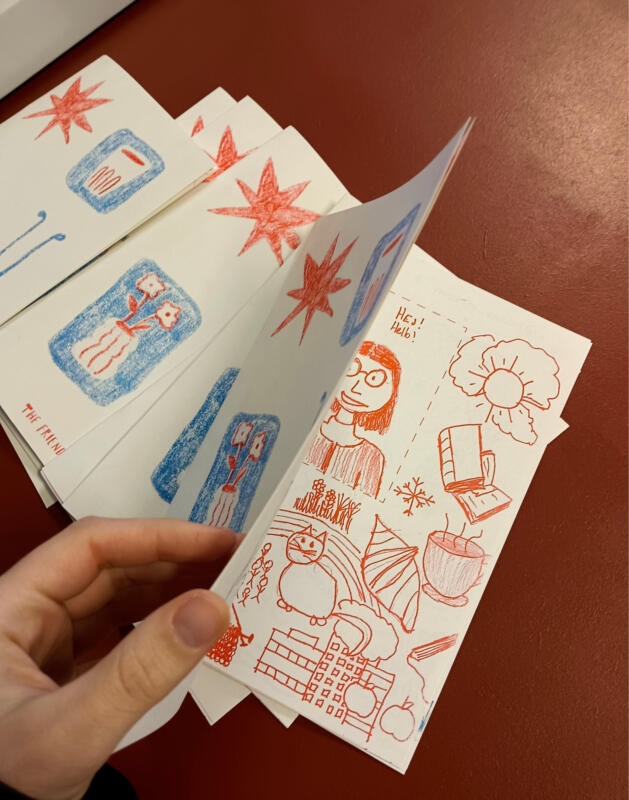 Hand som öppnar risotryckt häfte och visar inlaga