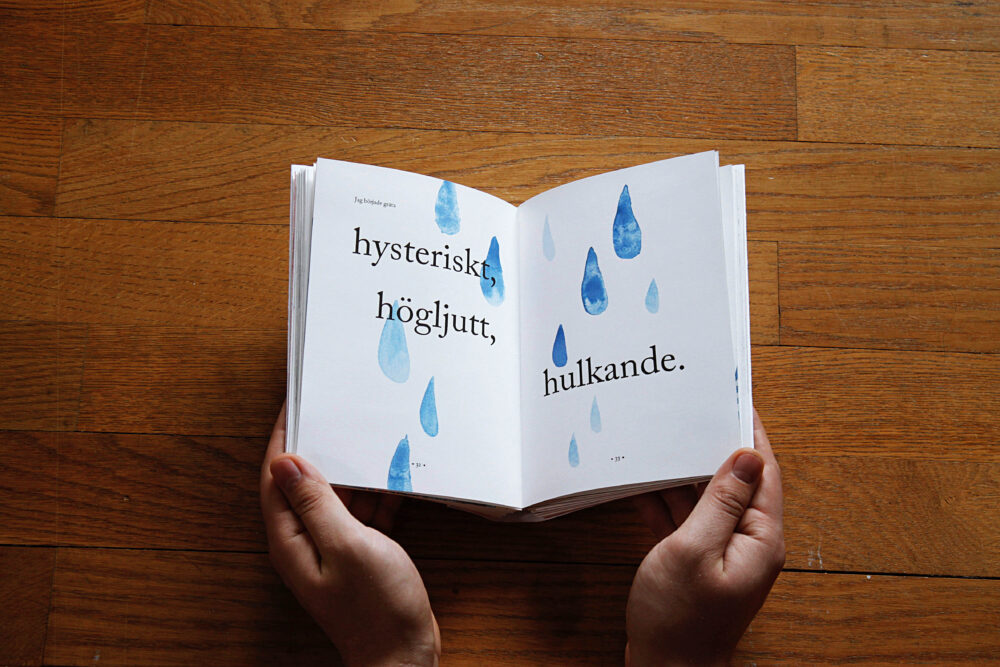 Ett foto på ett uppslag ur boken. Uppslaget är tårar målade i blå akvarell och man kan läsa texten "Jag började gråta hysteriskt, högljutt, hulkande."