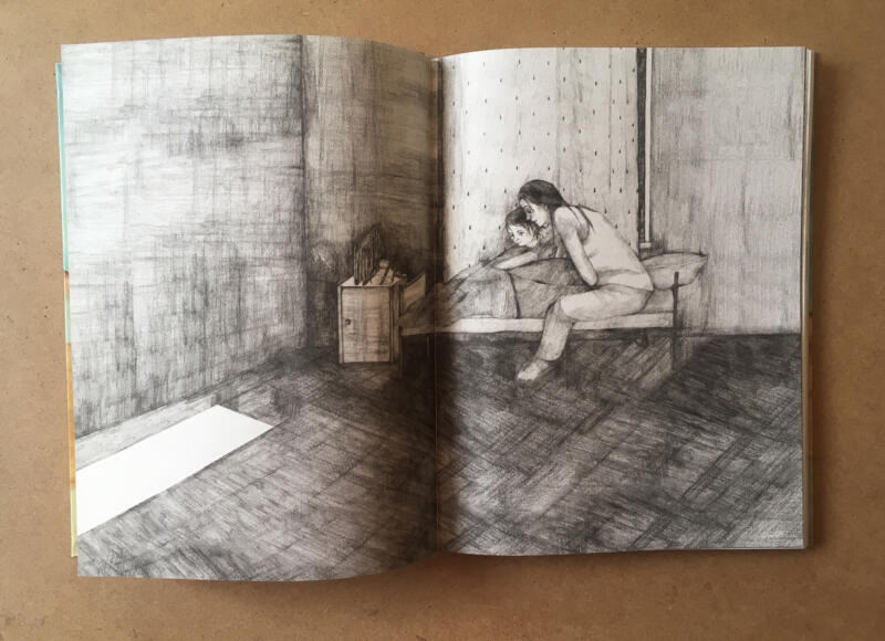 Fotografi föreställande boken Innanför min blåa dörr. På uppslaget syns en svartvit illustration av ett barn och en mamma som sitter nära varandra i barnets säng.