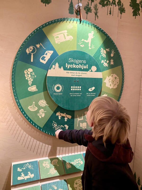 Snurra lyckohjulet, se vilken symbol du hamnar på? Se uppdraget under luckan. Utställningen Skoogla på Fulltofta naturcentrum.