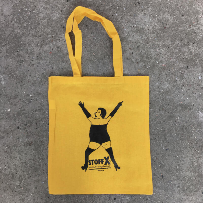 En kasse med en hen som står som ett X i tajta kläder, handskar och klackskor. Den högra handen gör ett fuckoff tecken (pekar finger). Mellan benen står det Stoff X (Stockholm Fringe festival 2019).