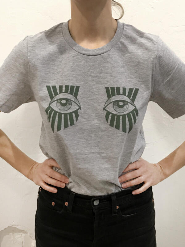 Beskuren bild på en kvinna som bär en grå t-shirt med gröna ögon. 