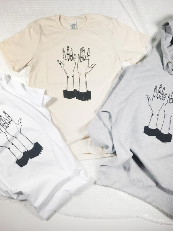 Beskuren bild av två vit/ benvit t-shirt och en grå hoodie, samtliga tryckt illustration på ett par händer. 
