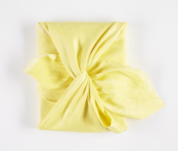 Bokomslag med handvävd knuten gul japansk furoshiki textil gjord av författaren. Furoshiki är en japansk textil och förpackningskonst.