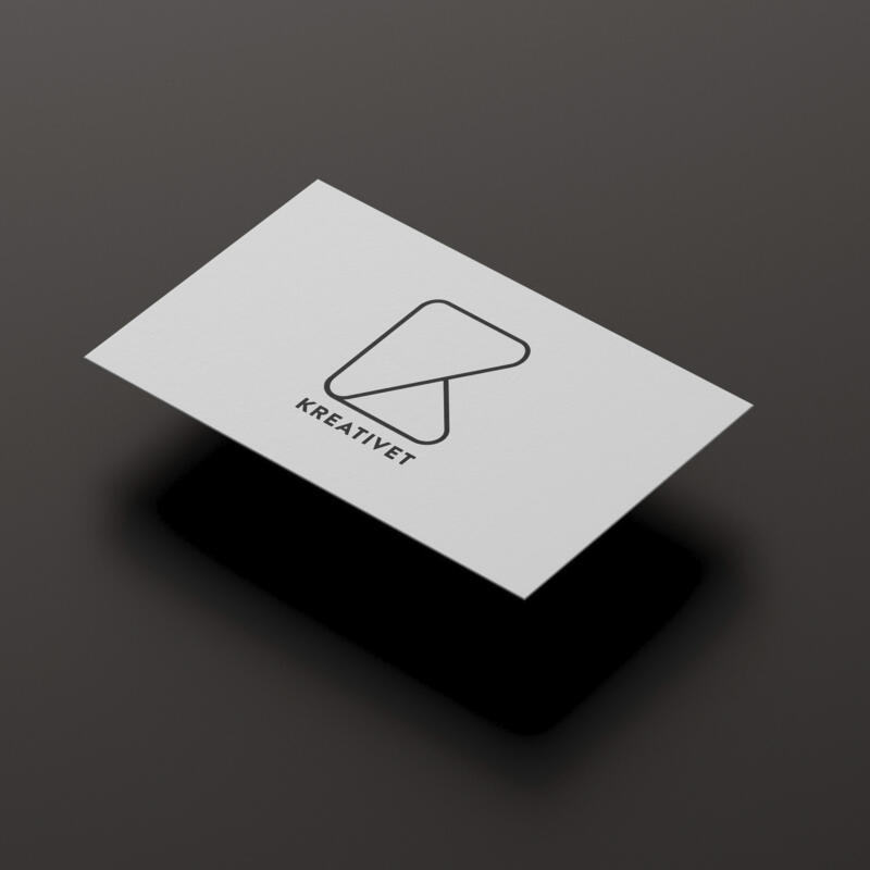Mockup av visitkort med dentitetsbärande logotyp där två trekanter med mjuka hörn bildar illustration av ett K. Under symbolen står Kreativet i versaler,