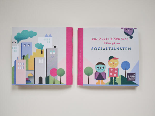 Omslagsbild till "Kim, Charlie och Sassa hälsar på hos Socialtjänsten". Motiv: barn, stad, träd, typografi, himmel. En färgstark bild