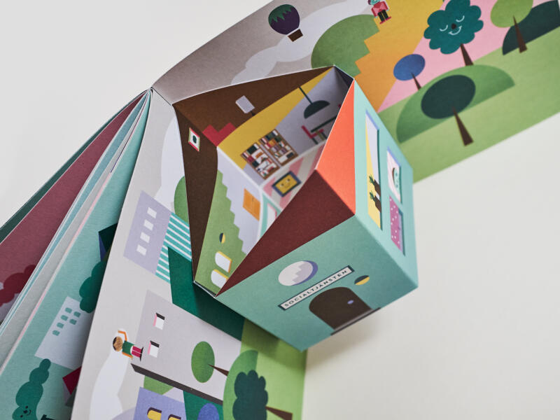 Uppslag med "pop-up" effekt från broschyren Kim Charlie och Sassa hälsar på hos socialtjänsten. Motiv: stad, människor, vuxna och barn, miljö, himmel, figur. boklayout, grafiska illustrationer, färgstarkt, lekfullt