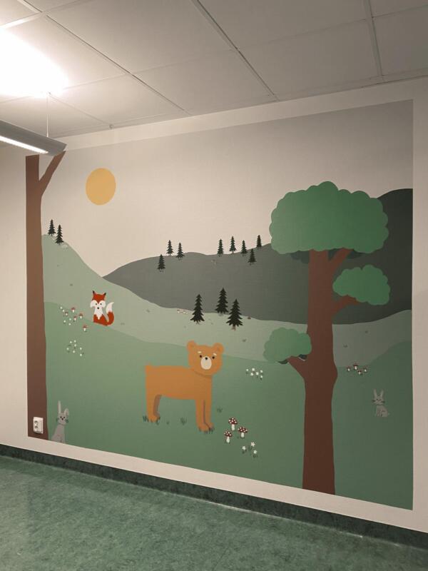 Muralmålning som föreställer en skog med djur såsom björn, kaniner och räv, och små svampar