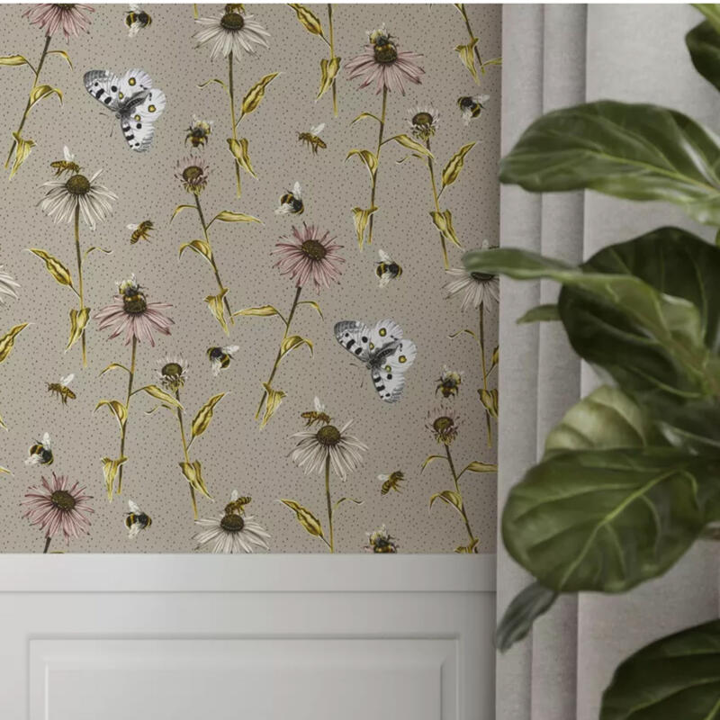Interiörbild med en romantisk mönsterdesign med blommor, fjärilar, humlor och bin på en beige prickig bakgrund. Färgskalan är harmonisk.