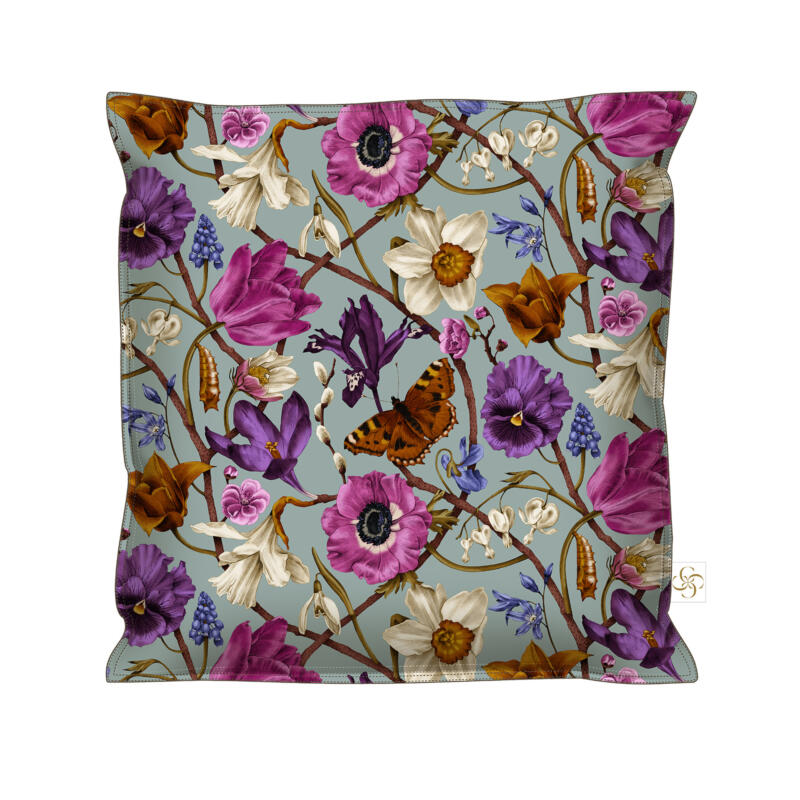 Ett kuddfodral med det sprudlande vårmönstret "SPRING" med många olika vårblommor, en fjäril och en puppa. Mönstret har klara färger i turkos, cerise, cognac, lila med vita accenter.