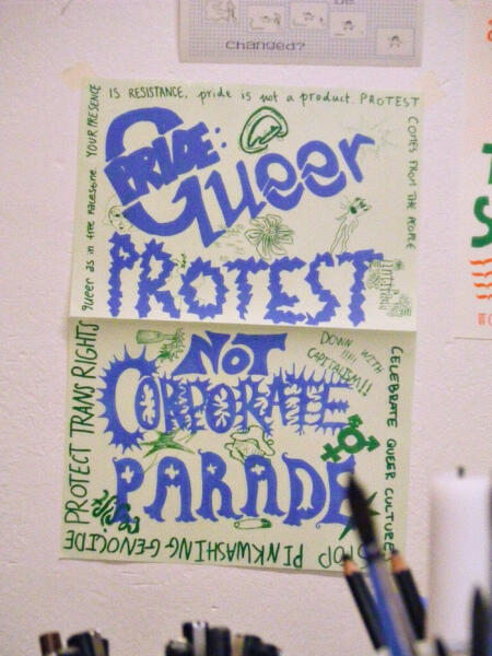 Stor A2-affisch, risoprintad. I stor handritad text står det “Pride: queer protest, not corporate parade”. Texten är omringad av små illustrationer och slagord.